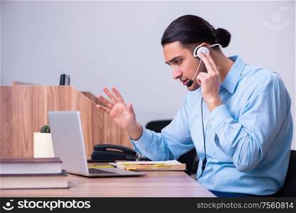 The call center operator working at his desk. Call center operator working at his desk