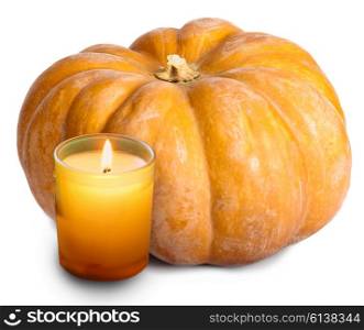 The candle burns before pumpkin on white background