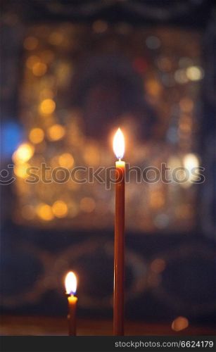 the candle burns on the background of the icons in the Orthodox Church