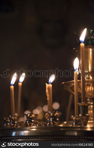 the candle burns on the background of the icons in the Orthodox Church