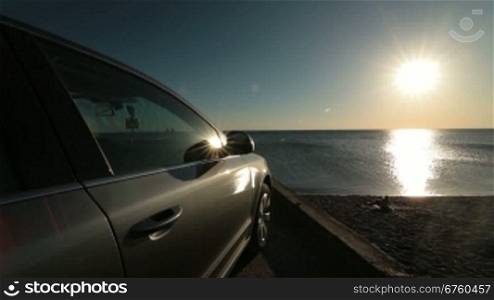 The car on the beach at sunset, wide-angle lens