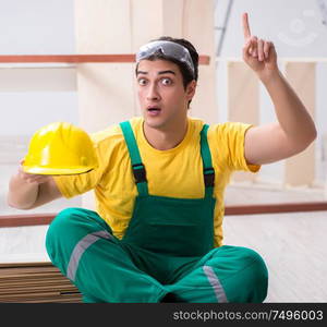 The carpenter wearing yellow hardhat in contractor workshop. Carpenter wearing yellow hardhat in contractor workshop