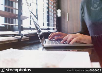 The Casual business woman works online on laptop which hand on keyboard