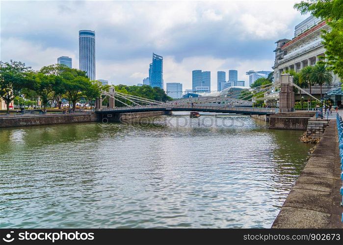 The Cavenagh Bridge with river in urban city, the only suspension bridge and one of the oldest bridge in Singapore Downtown.