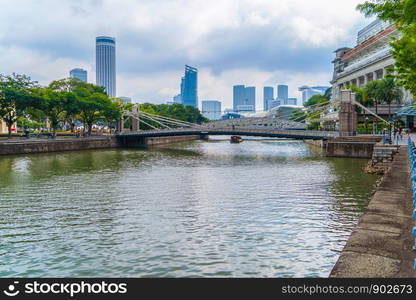 The Cavenagh Bridge with river in urban city, the only suspension bridge and one of the oldest bridge in Singapore Downtown.