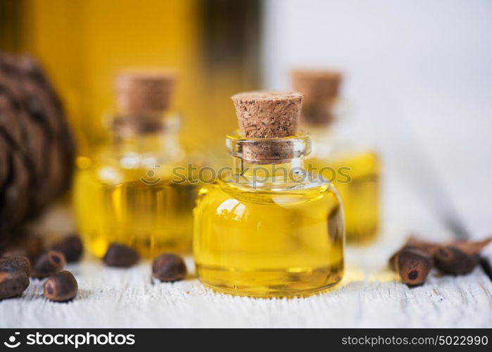 The cedar oil in a glass bottle. The cedar oil in a glass bottle on a white wooden background. Source of essential fatty acids for healthy nutrition