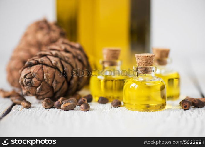 The cedar oil in a glass bottle. The cedar oil in a glass bottle on a white wooden background. Source of essential fatty acids for healthy nutrition