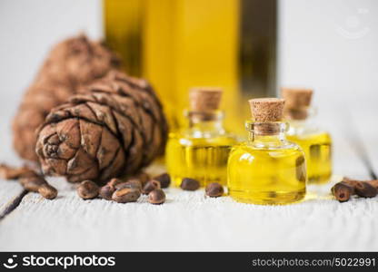 The cedar oil in a glass bottle. The cedar oil in a glass bottle on a white wooden background. Source of essential fatty acids for healthy nutrition