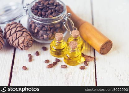 The cedar oil in a glass bottle. The cedar oil in a glass bottle on a white wooden background. Source of essential fatty acids for healthy nutrition