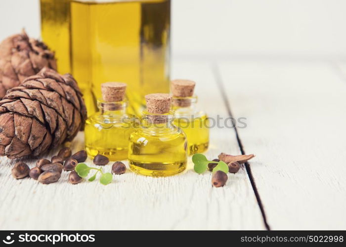 The cedar oil in a glass bottle. The cedar oil in a glass bottle on a white wooden background. Source of essential fatty acids for healthy nutrition