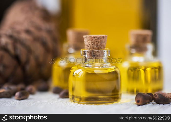 The cedar oil in a glass bottle. The cedar oil in a glass bottle on a white wooden background. Source of essential fatty acids for healthy nutrition