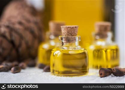 The cedar oil in a glass bottle. The cedar oil in a glass bottle on a white wooden background. Source of essential fatty acids for healthy nutrition