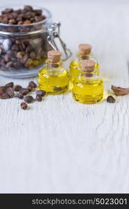 The cedar oil in a glass bottle. The cedar oil in a glass bottle on a white wooden background. Source of essential fatty acids for healthy nutrition