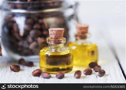 The cedar oil in a glass bottle. The cedar oil in a glass bottle on a white wooden background. Source of essential fatty acids for healthy nutrition
