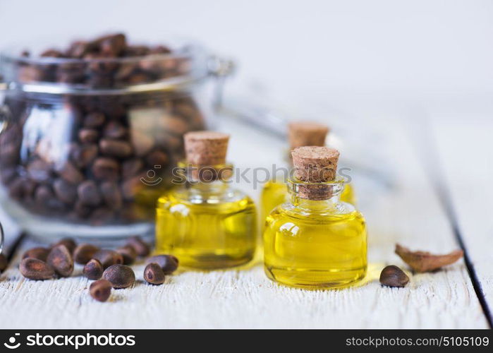 The cedar oil in a glass bottle. The cedar oil in a glass bottle on a white wooden background. Source of essential fatty acids for healthy nutrition