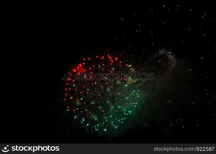 The Celebration multicolored firework flashing in the black night sky background