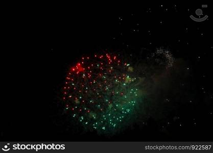 The Celebration multicolored firework flashing in the black night sky background