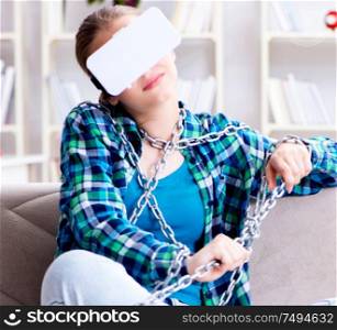 The chained female student with virtual glasses sitting on the sofa. Chained female student with virtual glasses sitting on the sofa