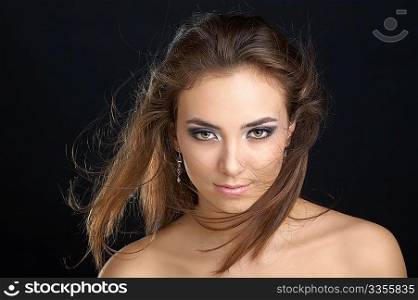 The charming girl with naked shoulders on a black background