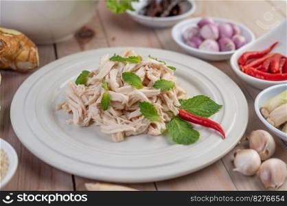 The chicken that is bordered is cooked and placed in a white plate along with mint leaves.