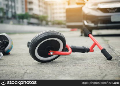 The child bike is on the ground with a car crash.