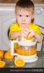 The child in a yellow vest to wring out juice from an orange