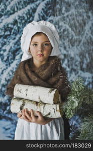 The child logs of firewood in a snowy forest.. Little girl in the winter forest collect firewood 4842.