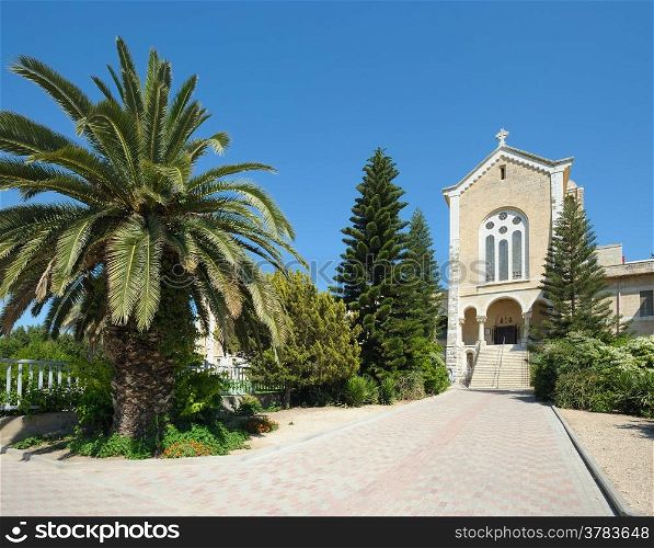 The church in the monastery Latrun, surrounded by flowers and trees (Israel)
