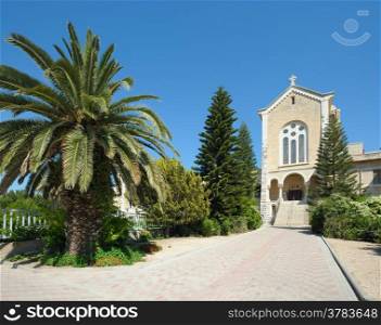 The church in the monastery Latrun, surrounded by flowers and trees (Israel)