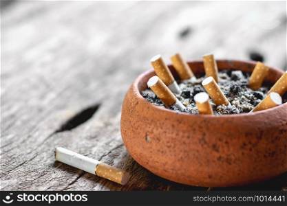 The cigarette butt in the pot is placed on an old wooden floor, World No Tobacco Day concept.