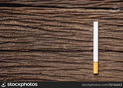 The cigarette is placed on an old wooden floor, World No Tobacco Day concept.