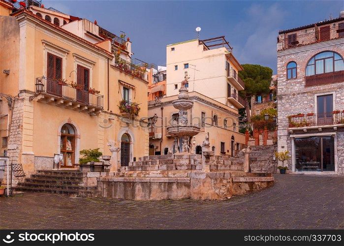 The city fountain of Taormina in front of the cathedral at dawn. Italy. Sicily.. Taormina. Sicily. City fountain.
