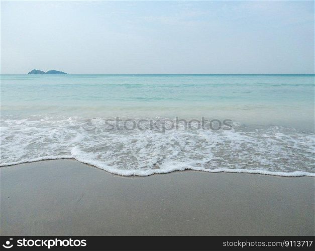 The clear soft waves from the sea on the quiet beach in the early morning with the peoplo, above view with the copy space.
