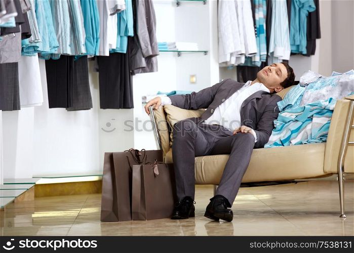 The client of shop of clothes sleeps on the sofa