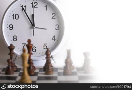 The Clock and Chess pieces on a chessboard. as background. The concept of playing and winning a chess tournament. Clock and Chess pieces on a chessboard. as background. The concept of playing and winning a chess tournament