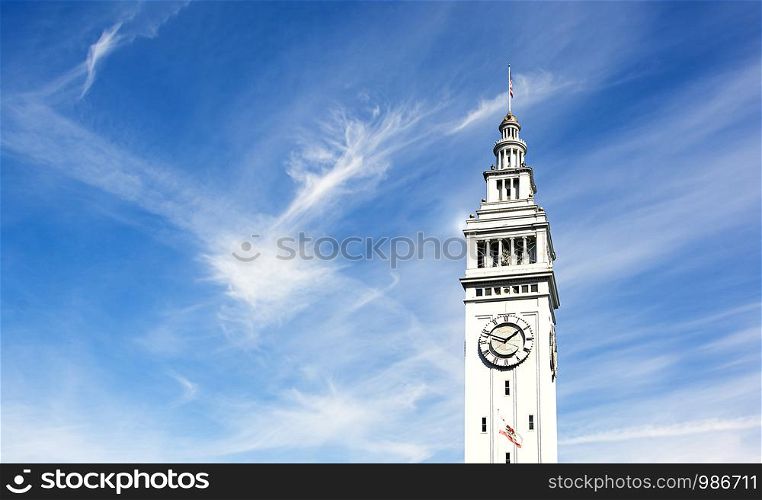 The clock tower of the Ferry Building in San Francisco on a clear day with light clouds