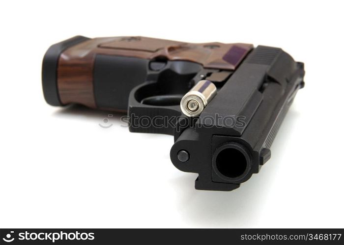 The close up of a pistol a target and cartridges is isolated on a white background