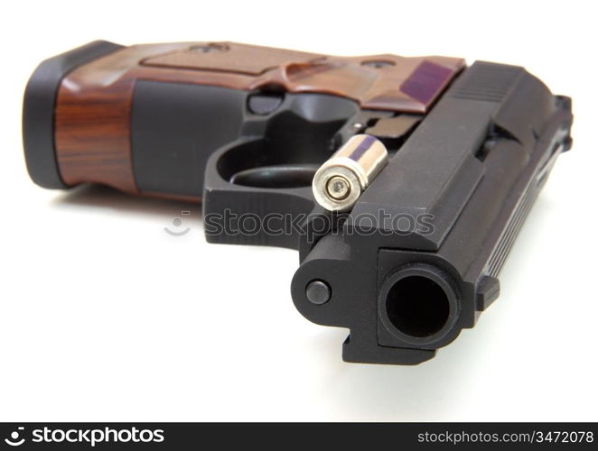 The close up of a pistol a target and cartridges is isolated on a white background