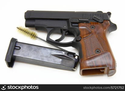 The close up of a pistol a target and cartridges is isolated on a white background