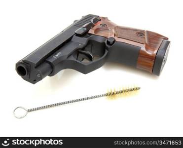 The close up of a pistol and Ruff for weapon cleaningis isolated on a white background