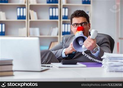 The clown businessman angry in the office with a megaphone. Clown businessman angry in the office with a megaphone