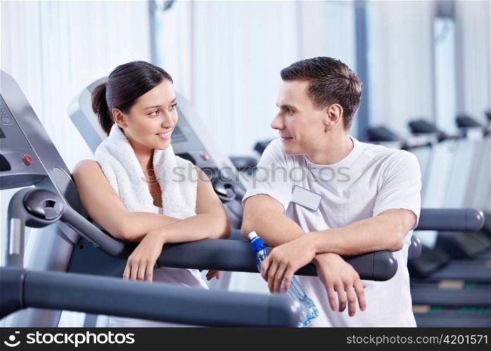 The coach was talking with a young girl at the fitness club