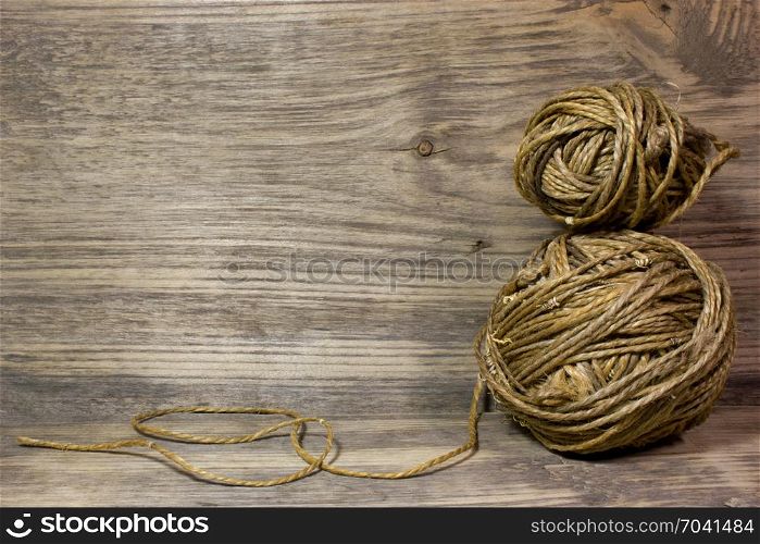 The coils of jute rope on wooden background. Free space for text.