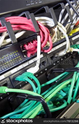 The color coded and neatly bracketed cables for network and telecommunications in an high tech server configuration