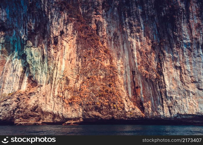 The colorful limestone cliffs of the Indian Ocean. Exotic Phi Phi Islands, the Kingdom of Thailand. Perfect background for the various kinds of the collages and illustrations.. The limestone cliffs. Phi Phi Islands, Thailand.