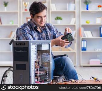 The computer repairman on wheelchair working. Computer repairman on wheelchair working