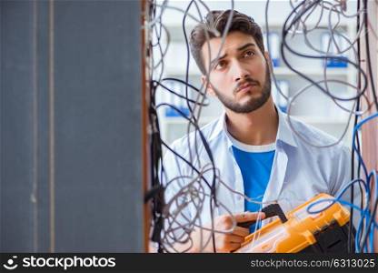 The computer repairman working on repairing network in it workshop. Computer repairman working on repairing network in IT workshop