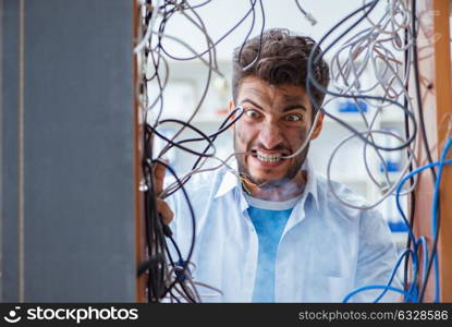 The computer repairman working on repairing network in it workshop. Computer repairman working on repairing network in IT workshop