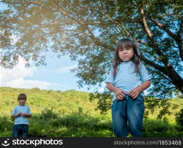 The conflict of the sisters during plays in the garden. Sibling relationship. Problems in family relationships between children.