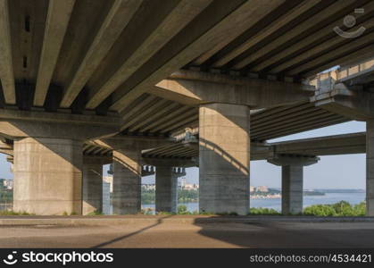 the construction of a bridge across the river with the supports, structural elements, cranes